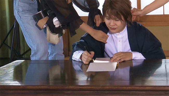 撮影前に、小道具の万年筆で実際に手紙を書く葉山さん