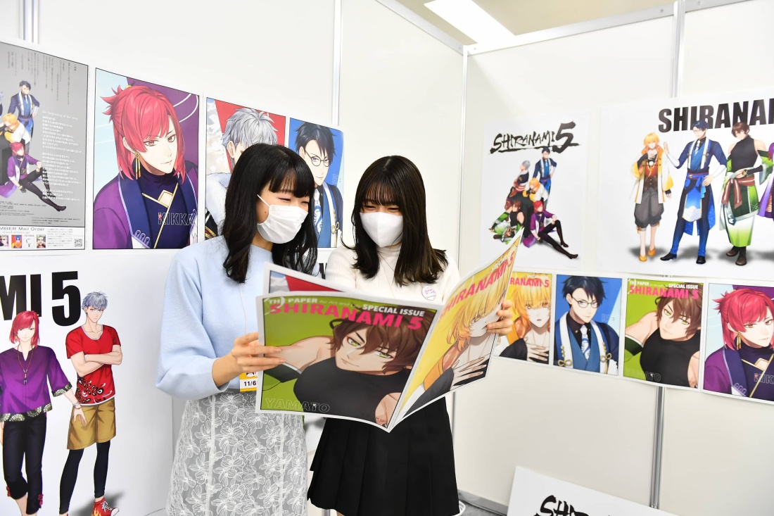 ポスターにもなる大判で迫力満点の「THE PAPER」をチェックする鼻炎ノ助(左)みずほ(右)